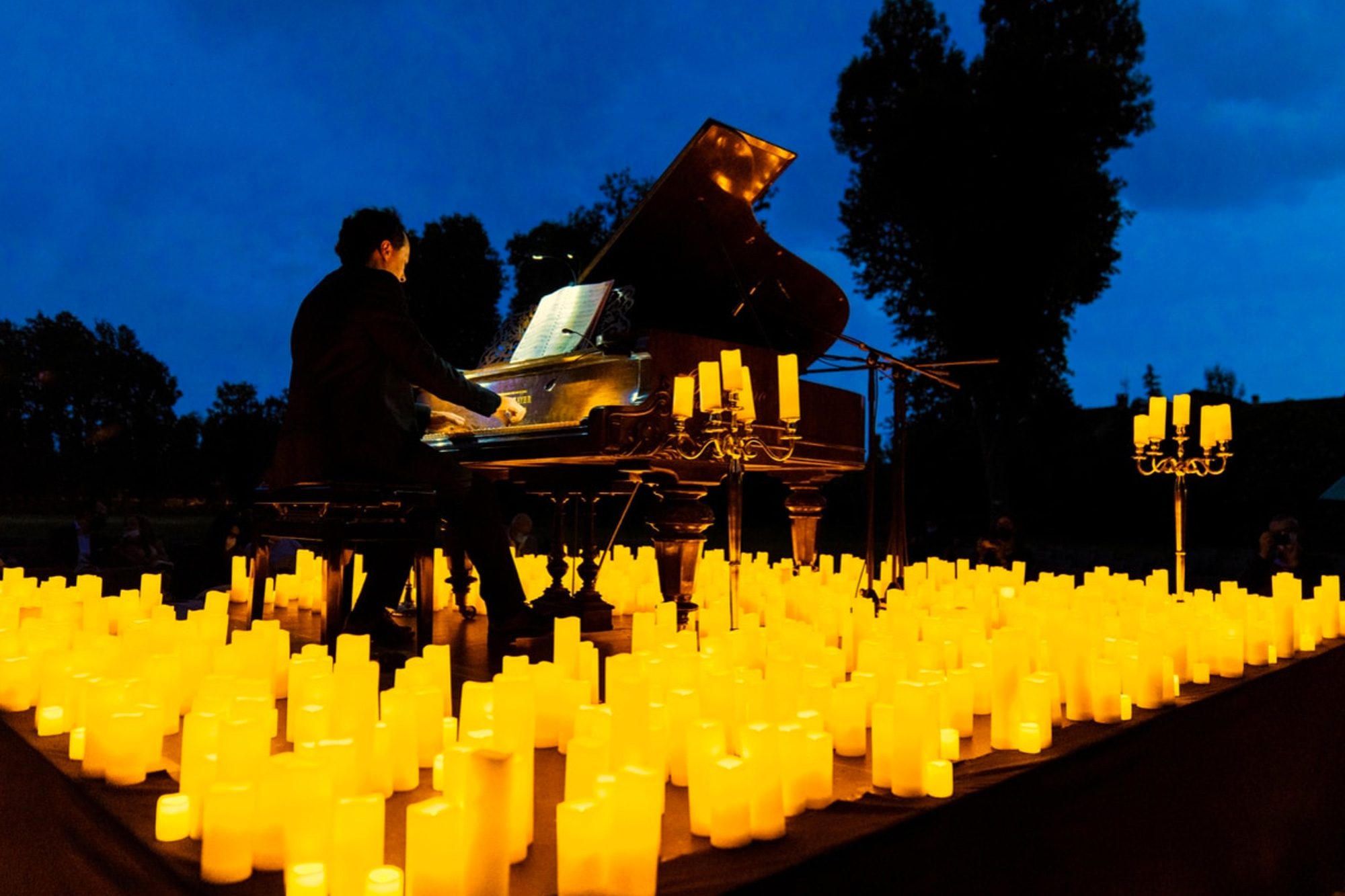 Candlelight, concerto in Villa Moroni: Ennio Morricone. Un pianista suona sotto il cielo serale circondato da candele